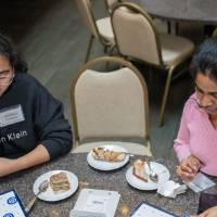 Two event attendees sitting together at table and playing bingo